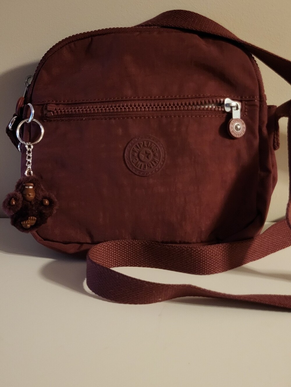 Kipling Compact Crossbody Bag in Maroon With Monkey Charm